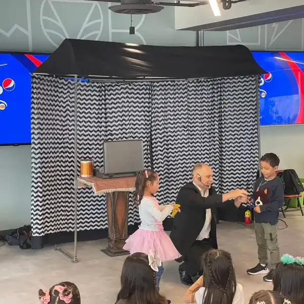 Presentación de magia en un escenario con pantallas